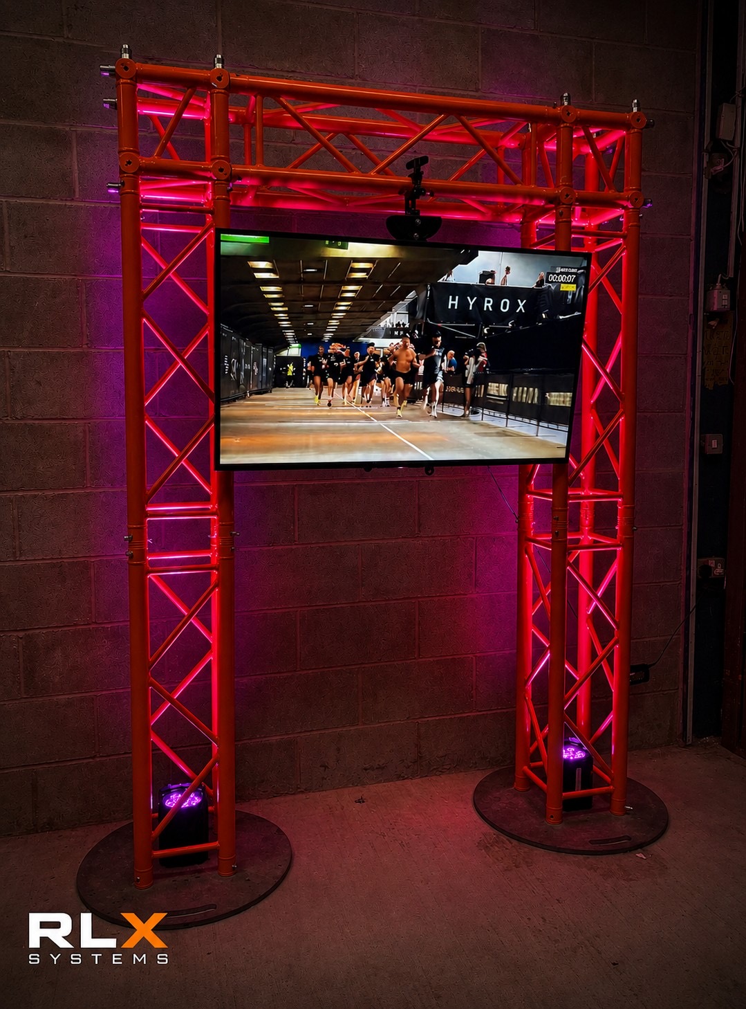 Screen mounted on orange truss goalposts with pink uplighting